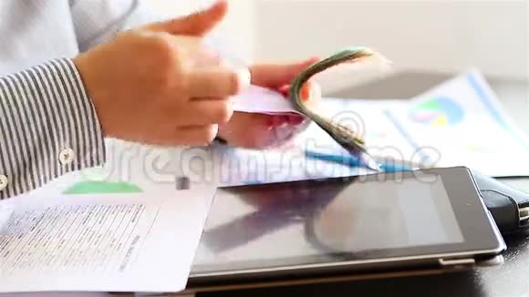 女人用手在平板电脑上数钱视频的预览图