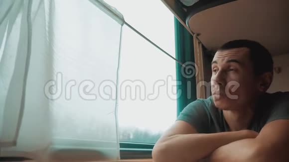人在火车上睡觉疲惫的长途铁路旅行火车铁路旅行慢动作录像窗外美丽视频的预览图