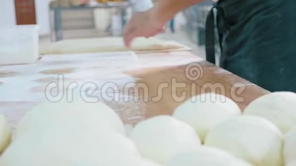 专业的面包师正在面包店的商业厨房里制作面团视频的预览图