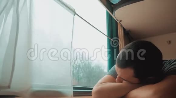 人在火车上睡觉疲惫的长途铁路旅行火车铁路旅行慢动作录像窗外美丽视频的预览图
