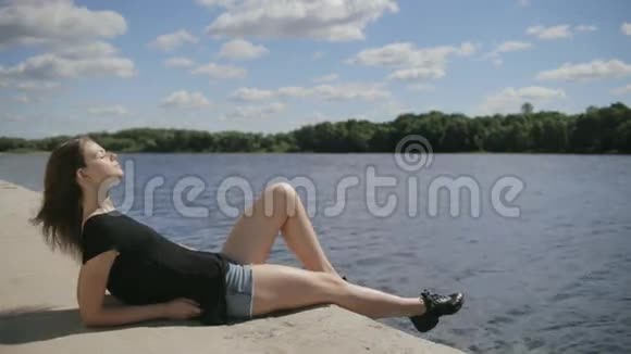 坐在河边的年轻漂亮女人闭着眼睛视频的预览图