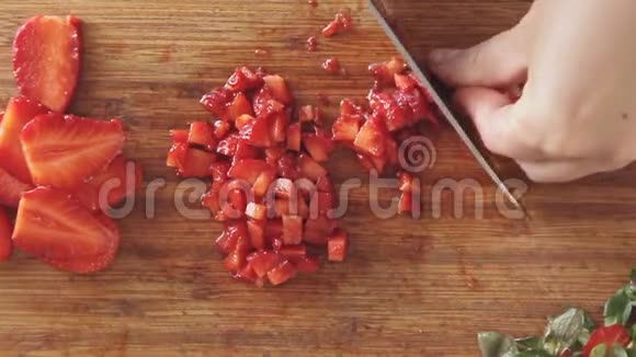 女人用手在木板上切草莓视频的预览图