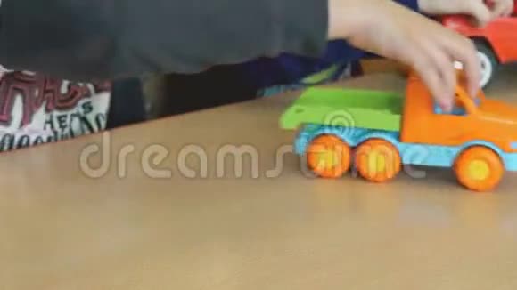 两个男孩在桌旁玩玩具模型车视频的预览图