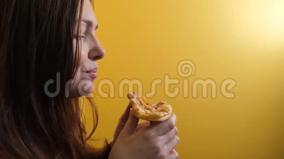 匹萨快乐女孩的生活方式吃一片披萨的概念饥饿的女人吃一片披萨慢动作视频的预览图