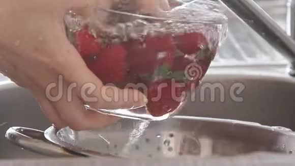 女人在水流下洗草莓视频的预览图
