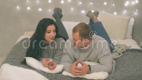 年轻夫妇在新年装饰和礼物和圣诞树上相爱视频里有噪音视频的预览图