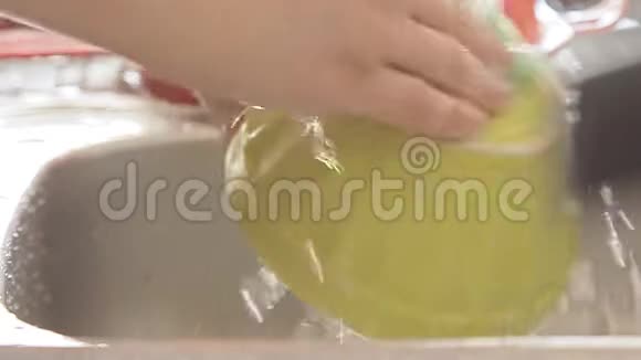 女人在水流下清洗厨房用具视频的预览图