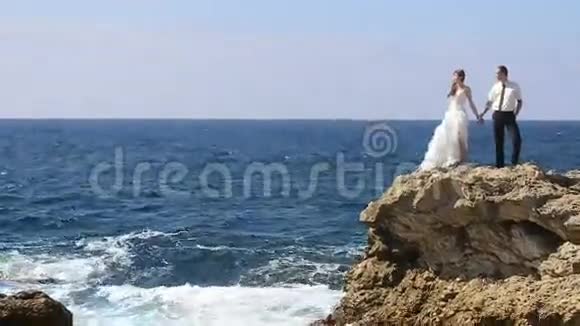 新郎新娘站在岩石上亲吻视频的预览图