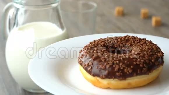 美味的甜圈巧克力糖霜旋转在盘子上粗糙的木桌失踪了视频的预览图