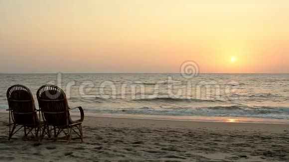 日落时靠近海岸线的椅子视频的预览图