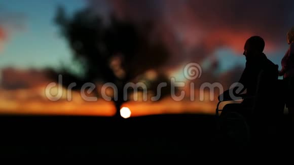 老两口在绿茵草地上欣赏着橡树的日出时光流逝的云彩淘沙视频的预览图