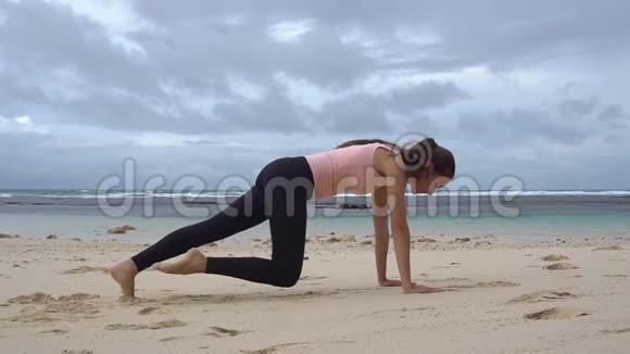 女子训练木板运动在海前沙滩视频的预览图