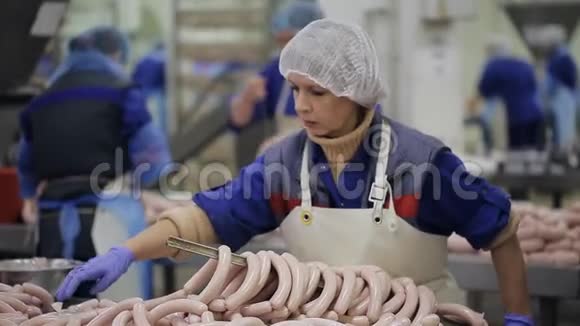 肉类产品制造生产部门员工整理香肠的末端工人在线香肠上视频的预览图