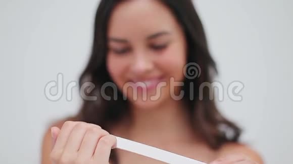 微笑的黑发女人整理她的指甲视频的预览图