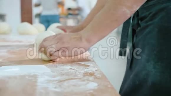 专业的面包师正在面包店的商业厨房里制作面团视频的预览图