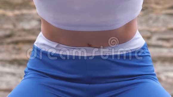 平腹女孩在横膈膜呼吸锻炼身体在岩石背景腹部特写镜头视频的预览图