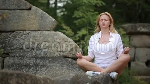 坐在石头上沉思的女人视频的预览图