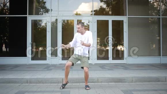 快乐的白种人舞蹈家男子时髦的街头舞蹈自由式城市视频的预览图
