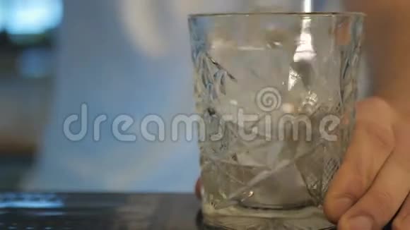 特写镜头酒吧男用勺子把冰混在玻璃里视频的预览图