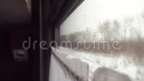 玻璃窗上的雨雪铁路概念火车旅行从火车的窗户可以看到美丽的景色视频的预览图
