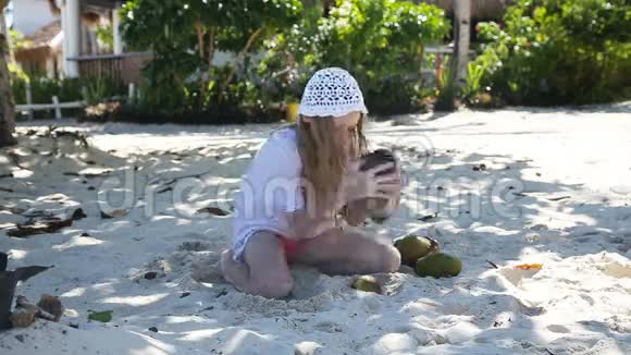 小女孩在海滩上玩椰子视频的预览图