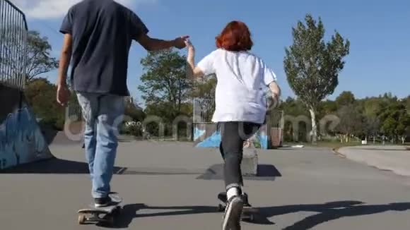 在溜冰场玩滑板的男人和女孩视频的预览图
