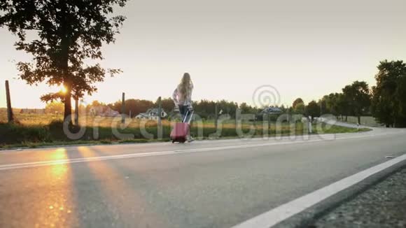 开朗的女人带着手提箱在路上行走视频的预览图