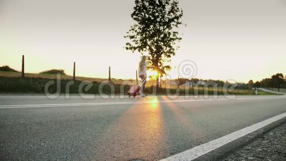 开朗的年轻女人带着手提箱在路上行走视频的预览图