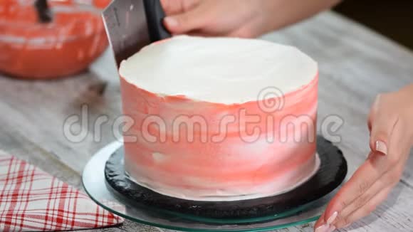 在面包店用糖霜装饰蛋糕的女人视频的预览图