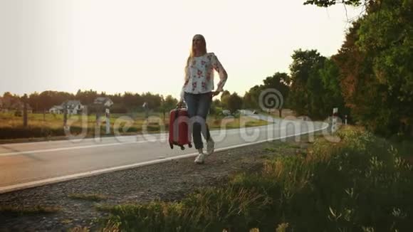 开朗的女人带着手提箱在路上行走视频的预览图