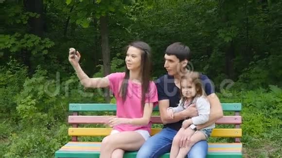 公园智能手机自拍的幸福家庭视频的预览图