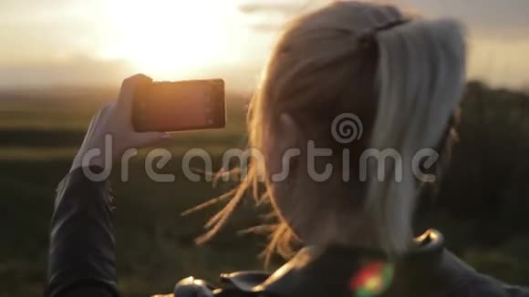 年轻女人把太阳带到你的智能手机上视频的预览图