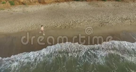 早上慢跑的家伙沿着海边的冲浪线在夏天视频的预览图
