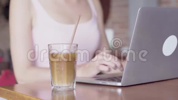 年轻女子在手提电脑上工作喝咖啡视频的预览图