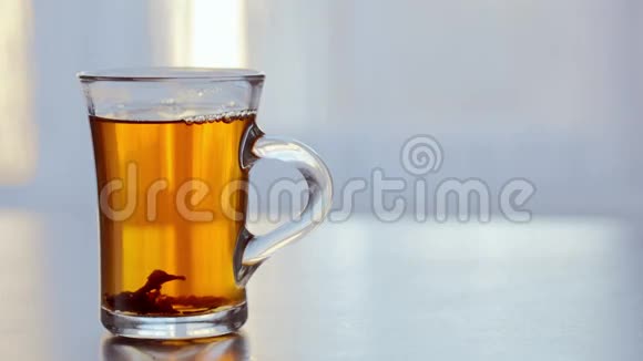 桌上一杯热气腾腾的热茶靠在窗户上视频的预览图