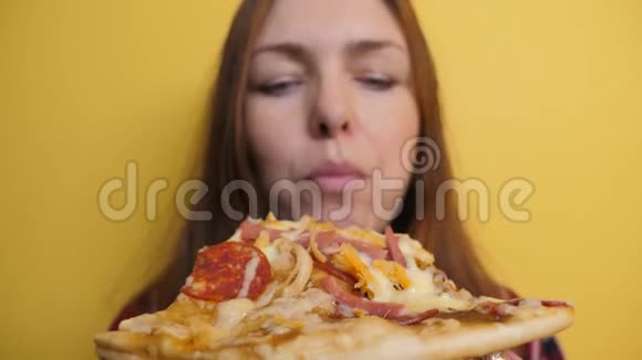 匹萨快乐女孩吃一片披萨的概念饥饿的女人吃一片比萨饼的生活方式慢动作视频的预览图