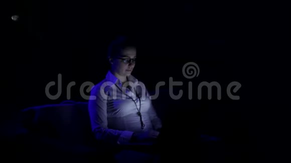 疲惫的商务女性戴着眼镜深夜在办公室笔记本电脑里工作视频的预览图