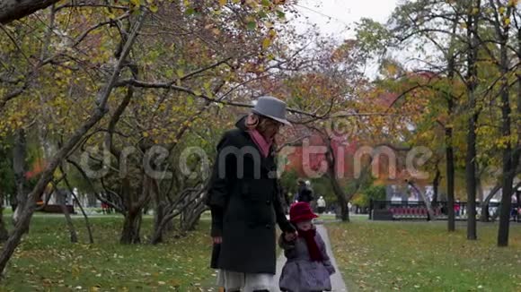 一个年轻的女人和她的女儿在公园里走来走去在小巷里玩耍和奔跑视频的预览图