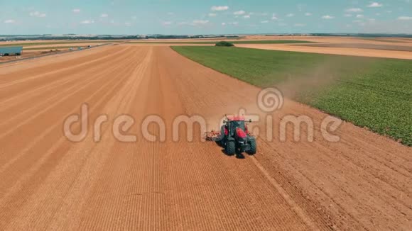在麦田工作的红色有轨电车的空中无人机视图欧洲联盟的农业和环境视频的预览图