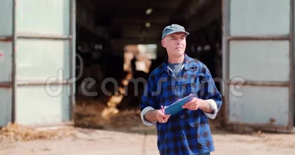 农民对牛棚剪贴板的分析和书写视频的预览图