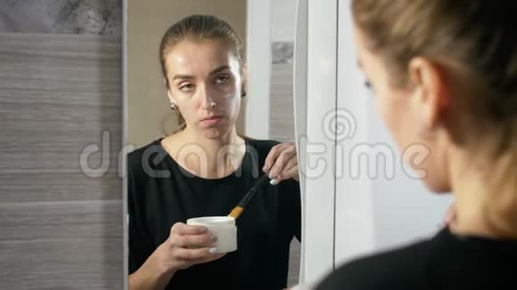 脸上长痘的女孩是镜子旁边的浴室视频的预览图