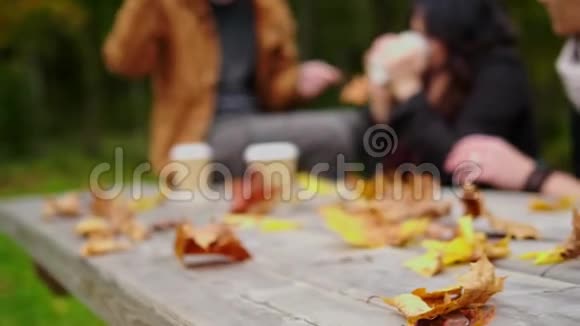 秋天公园木桌后面的朋友视频的预览图