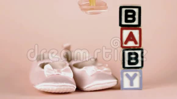 粉红色的肥皂落在婴儿鞋和婴儿积木前面视频的预览图