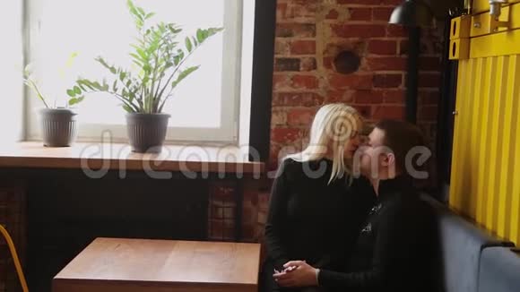 爱的一对夫妻坐在咖啡馆里聊天互相看着对方视频的预览图