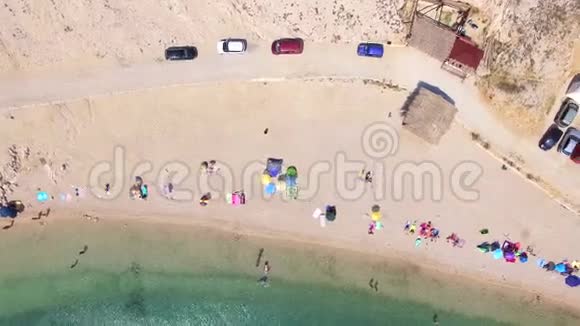在帕格岛沙滩上停着车和人的上空飞行视频的预览图