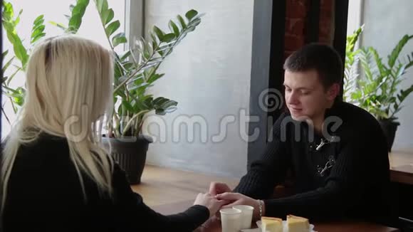 爱的一对夫妻坐在咖啡馆里聊天互相看着对方视频的预览图