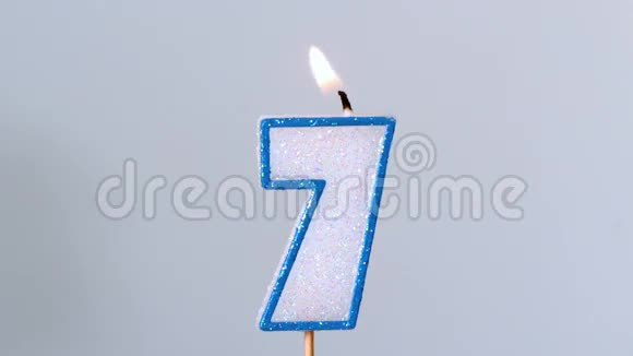七岁生日蜡烛在蓝色背景下闪烁熄灭视频的预览图