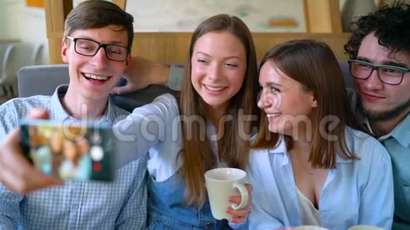 微笑的朋友坐在咖啡馆里玩得开心交流自拍视频的预览图