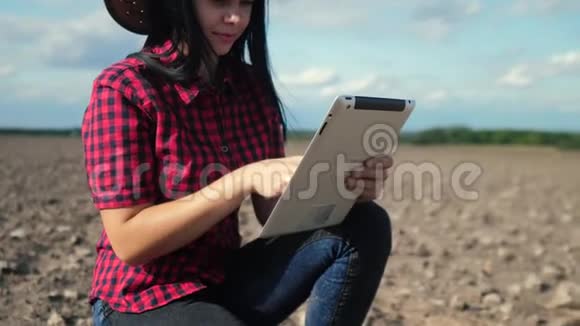 智慧生态是一种收获农业的耕作理念女农民用数字平板电脑研究田野里的泥土视频的预览图