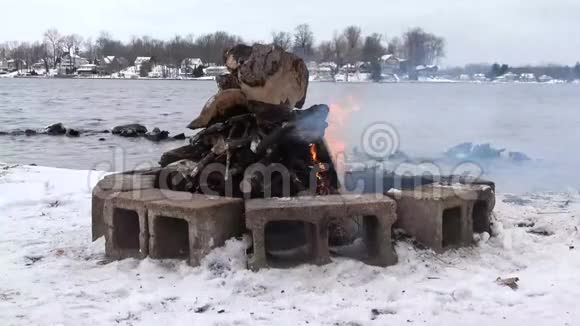 冬令营火沿雪湖岸前视频的预览图